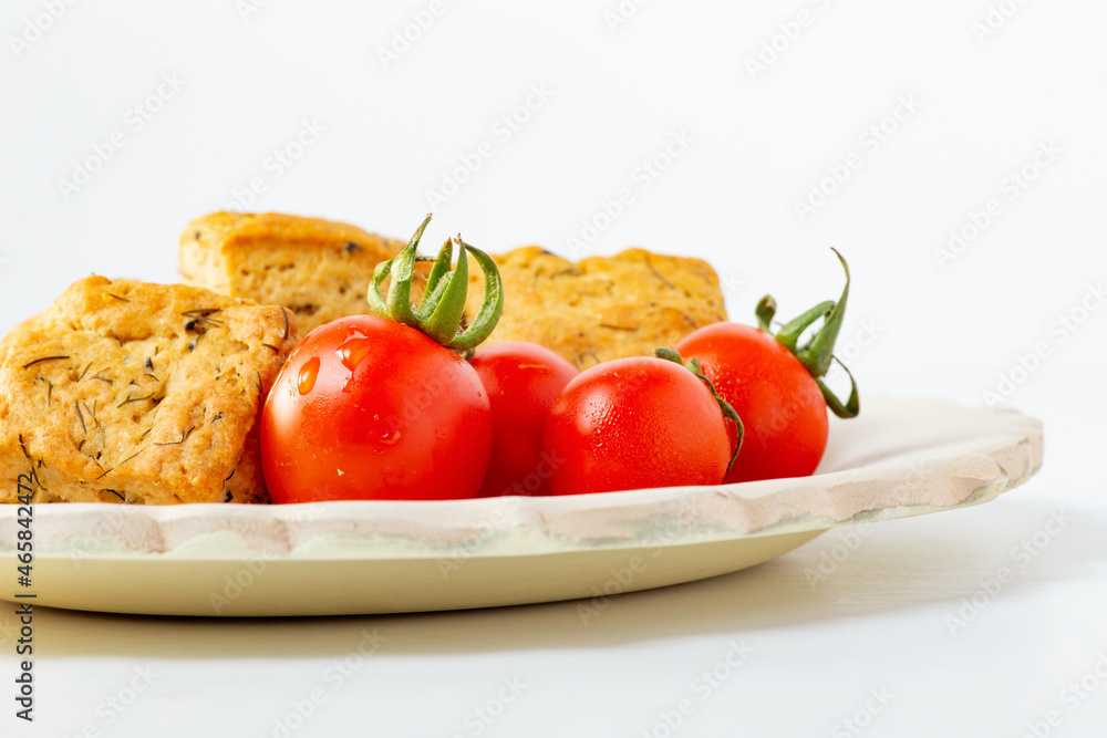 Dill cookies with cherry tomato on the plate white background. Dill cookies with cherry tomato on the plate white background.