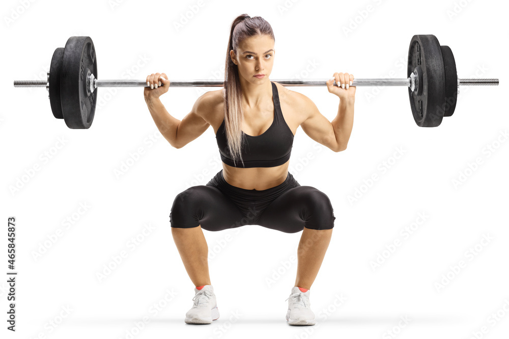Full length portrait of a young female bodybuilder lifting weights and kneeling Full length portrait of a young female bodybuilder lifting weights and kneeling