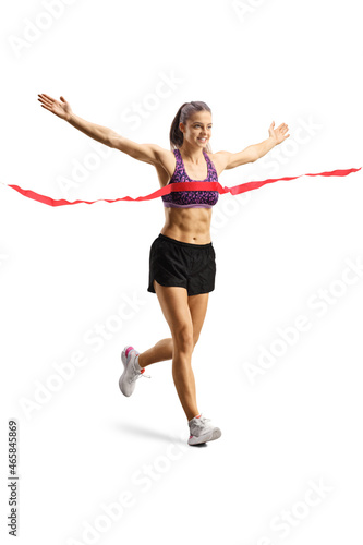 Full length shot of a fit young female runner finishing a race with arms wide open