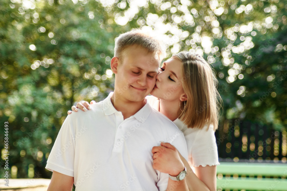Fototapeta premium A loving guy and a girl are walking in the park. The concept of an outdoor love story.