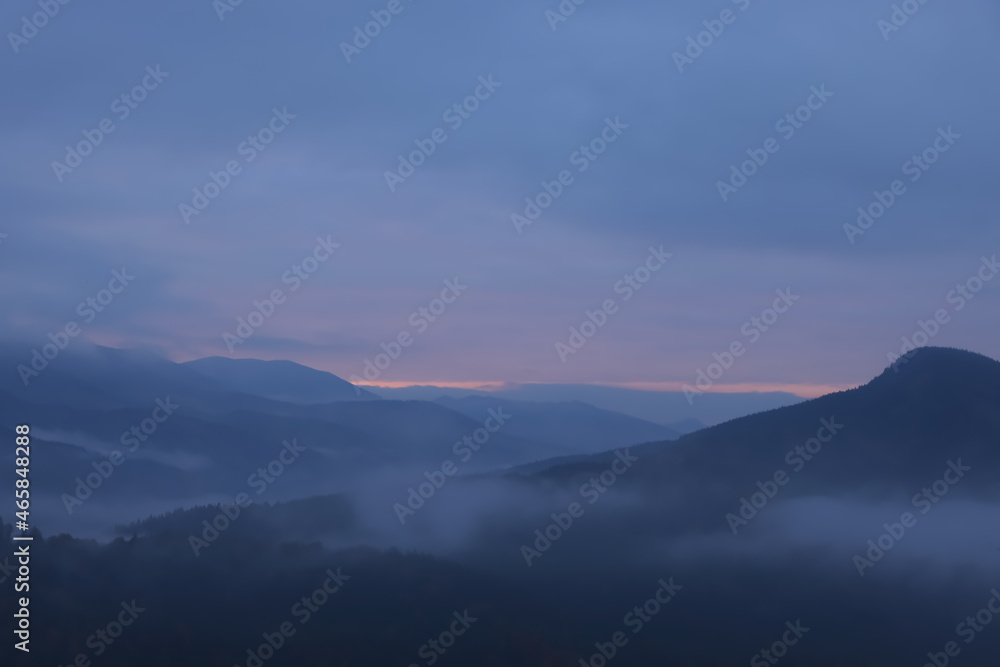 Beautiful view of mountains covered with fog during sunrise Beautiful view of mountains covered with fog during sunrise