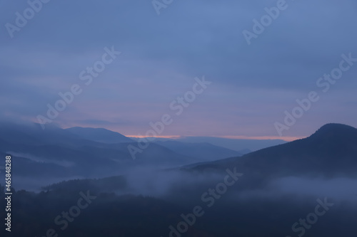 Beautiful view of mountains covered with fog during sunrise © New Africa