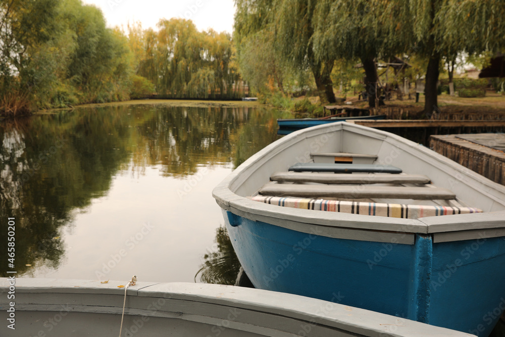 Light blue wooden boat on lake, space for text Light blue wooden boat on lake, space for text