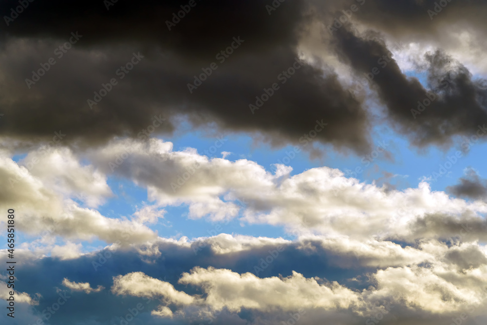 Fototapeta premium The sunset sky is blue with dark and light clouds above.