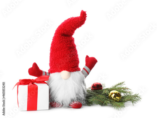 Funny Christmas gnome with gift box and festive decor on white background photo