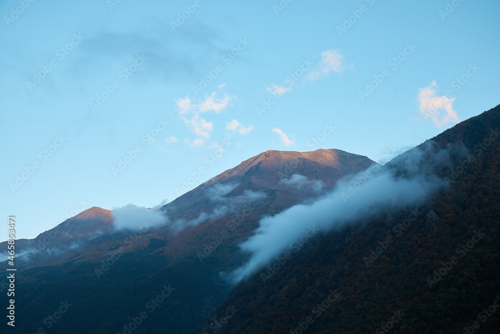 mountain landscape, forest on the slope and rocks in the clouds, evening in the highlands, summer mountain landscape, forest on the slope and rocks in the clouds, evening in the highlands, summer