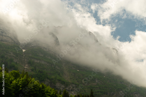 Appenzell, Switzerland, June 13, 2021 Mountain peaks in clouds and green trees