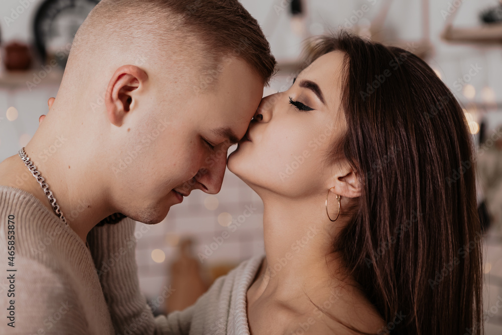 Close up lovely young romantic couple standing kissing hugging home cosy interior atmosphere New Year Christmas decorations mood holiday party celebrating concept winter evening copy space
