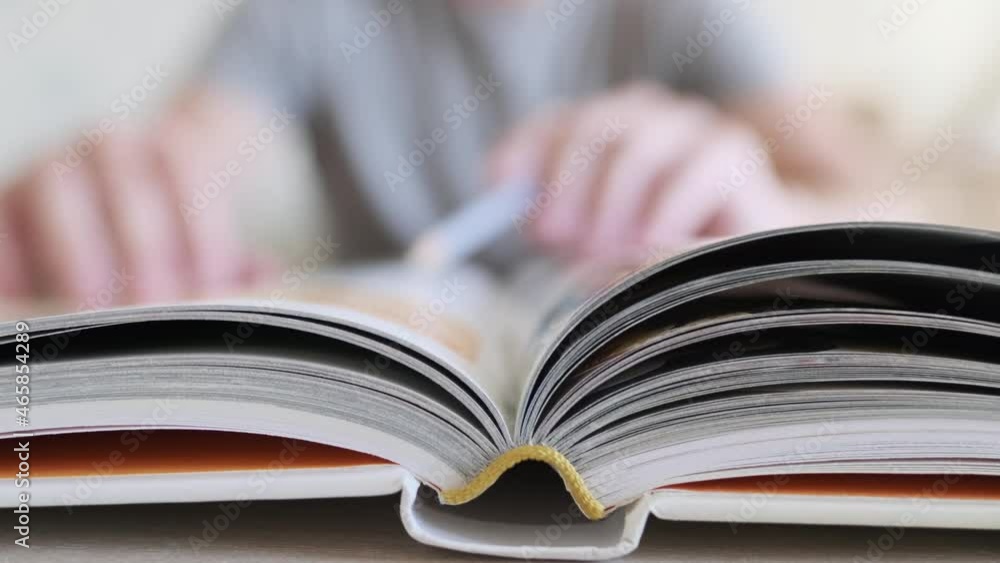 Closeup view of open book lying on table and teaching man in blurred background Closeup view of open book lying on table and teaching man in blurred background