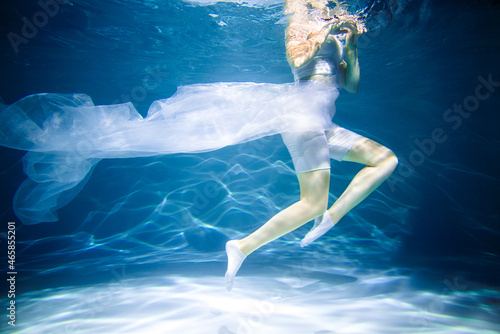 Women s health concept. Girl underwater in white. lightness  freshness and health