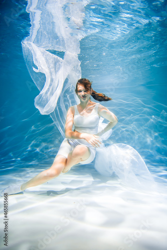 Women's health concept. Girl underwater in white. lightness, freshness and health
