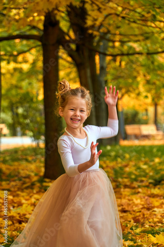 Little girl princess Selective focus in yellow autumn in fluffy skirt. Orange greens happy child playing outside. Fun outdoor play in new park new home. Childhood concept. Laughs smiles beautifully.