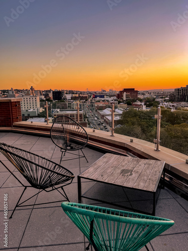 Table and chairs from a Brooklyn Rooftop overlooking Gowan's and the Hudson River at sunset  photo