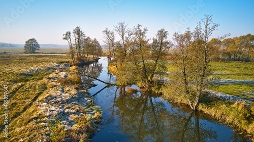 Obraz na płótnie Autumn rural landscape. Frost on grass. River, green field, meadow, trees on riverbank. w salonie
