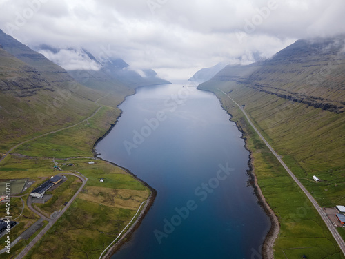 Beautiful aerial view of Faroe Islands Towns next to the ocean Canals, and boats and massive mountains.  © Gian