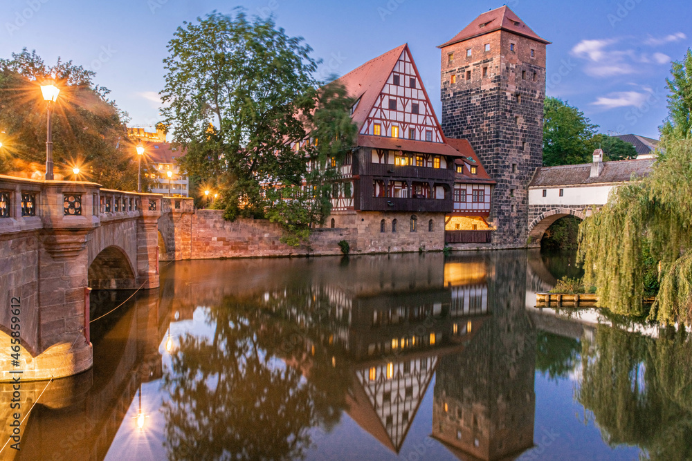 A colourful and picturesque view of the half-timbered old houses on the banks of the Pegnitz river in Nuremberg, Franconia Germany, illuminated at night