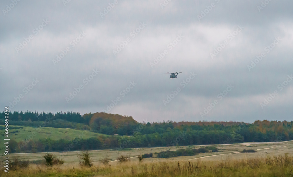 British Royal Navy AgustaWestland Merlin HM.2 AW101 helicopter on a military exercise over Wiltshire UK, low grey cloud British Royal Navy AgustaWestland Merlin HM.2 AW101 helicopter on a military exercise over Wiltshire UK, low grey cloud