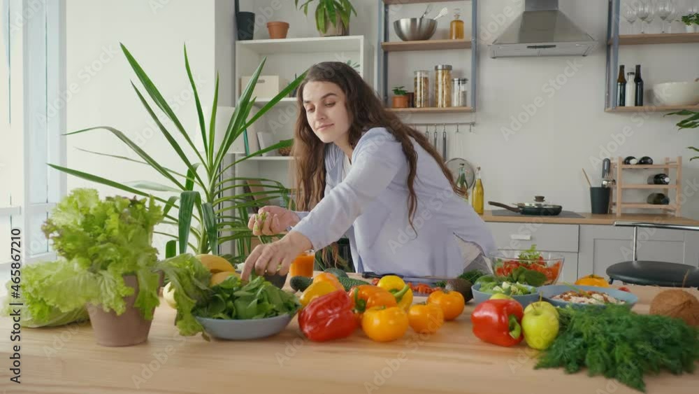Happy Pregnant Woman Enjoying Preparing a Salad, Cutting Organic Vegetables in Home Kitchen With Modern Interior. Healthy Eating During Pregnancy. A Pregnant Woman Prepares Food at Home. Happy Pregnant Woman Enjoying Preparing a Salad, Cutting Organic Vegetables in Home Kitchen With Modern Interior. Healthy Eating During Pregnancy. A Pregnant Woman Prepares Food at Home.