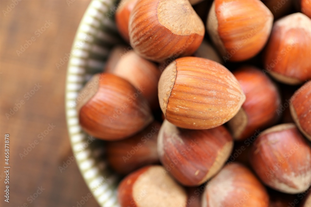 ripe hazelnuts close-up in a round cup on a wooden table.Vegetable protein . healthy snack. Healthy fats. Farmed organic ripe hazelnuts