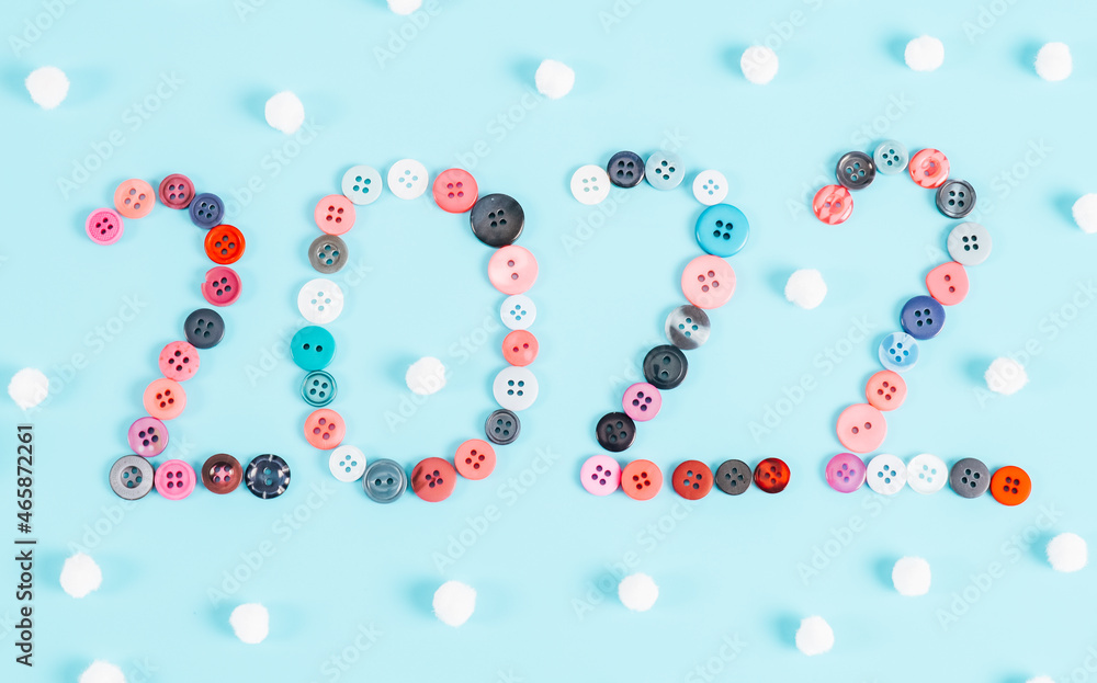 Number 2022 from multicolored buttons and balls of snowflakes on light blue. Number 2022 from multicolored buttons and balls of snowflakes on light blue.