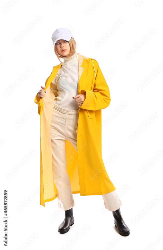 Young woman in yellow coat and baseball cap on white background Young woman in yellow coat and baseball cap on white background
