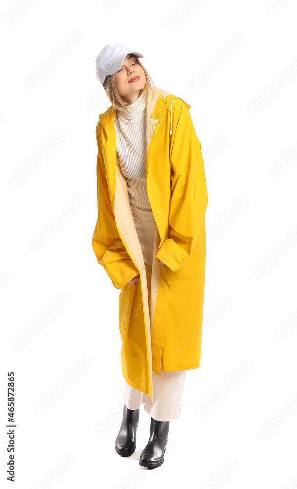Young woman in yellow coat and baseball cap on white background Young woman in yellow coat and baseball cap on white background