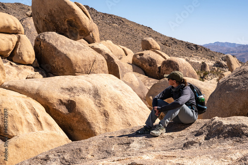 Woman Hiker Sits and Looks Off In The Distance