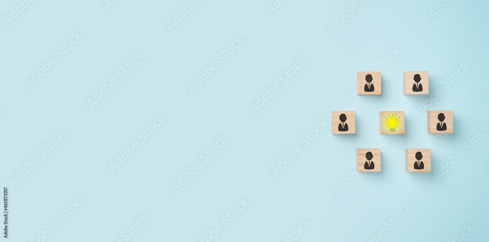 Wooden cube block with head human symbol and light bulb icon on blue background, copy space, Concept creative idea and innovation, idea, teamwork. Wooden cube block with head human symbol and light bulb icon on blue background, copy space, Concept creative idea and innovation, idea, teamwork.