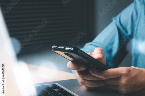 Woman hand using smartphone on home office.