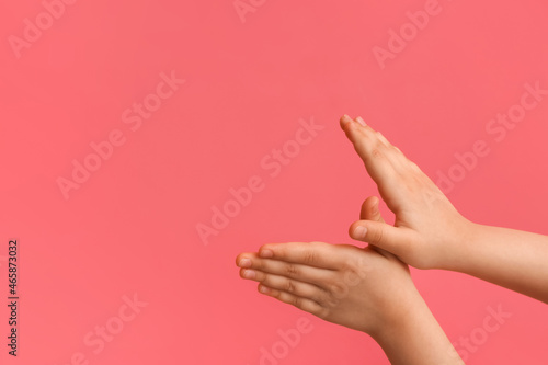 Child performing a shadow play on color background