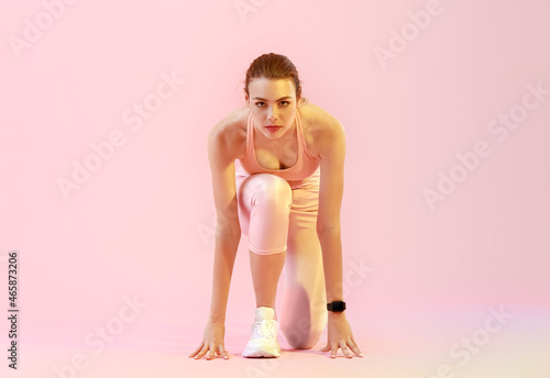 Sporty young woman in crouc...