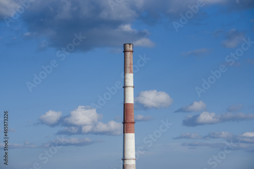 close-up factory brick chimney. pipe cogeneration plant on the sky background. Ambient air pollution industrial emissions