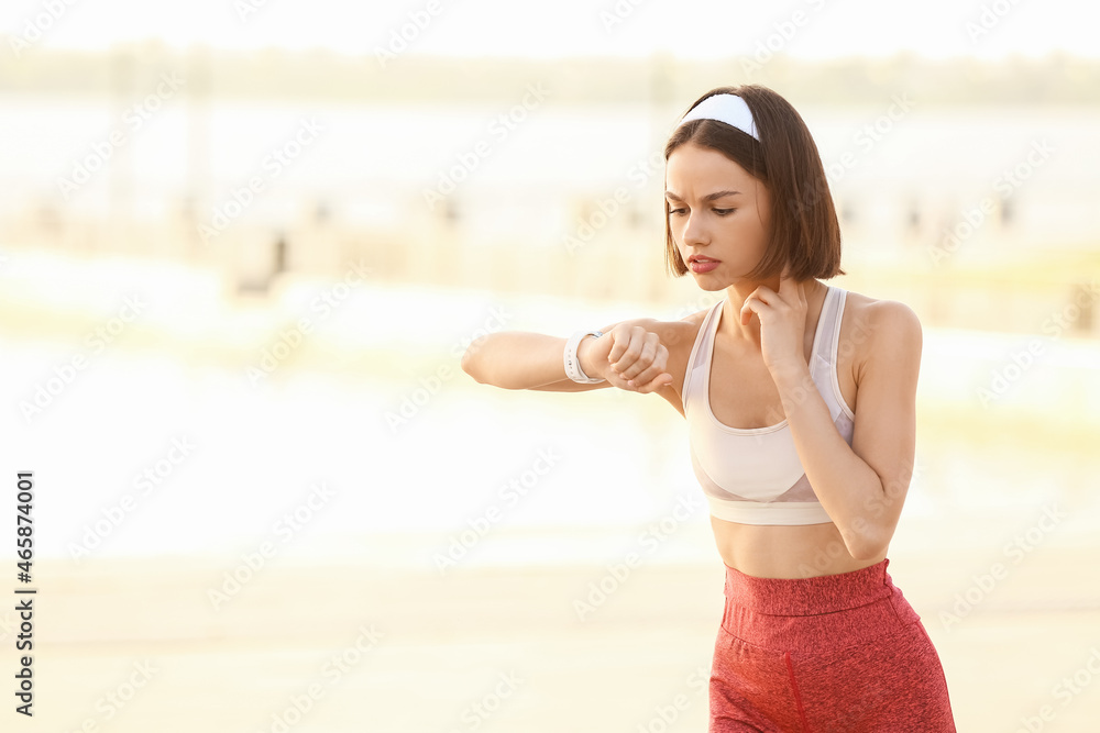 Sporty female runner checking pulse outdoors Sporty female runner checking pulse outdoors