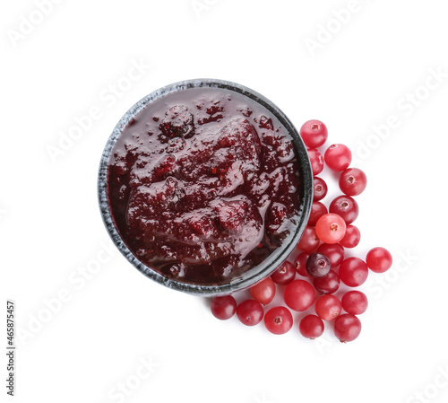 Bowl of tasty cranberry jam and fresh berries on white background
