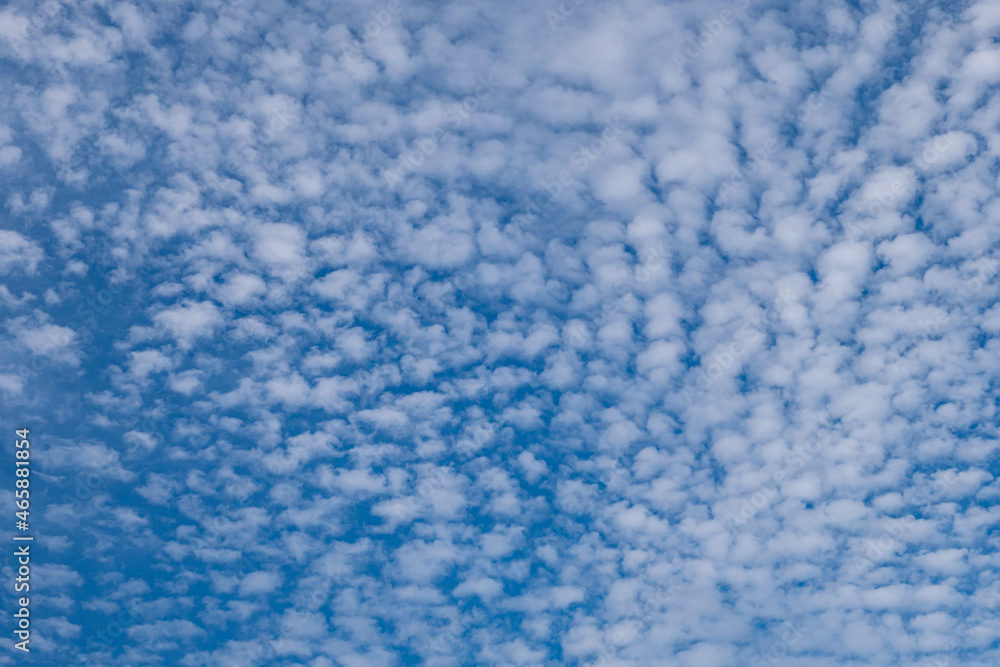background texture of blue sky filled with small cluster of clouds