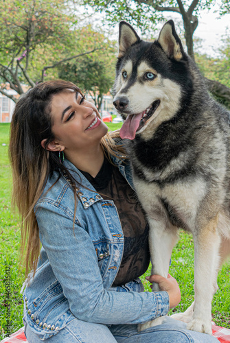 Siberian dog  black and white  playing in a park in Bogot    Colombia  with its owner