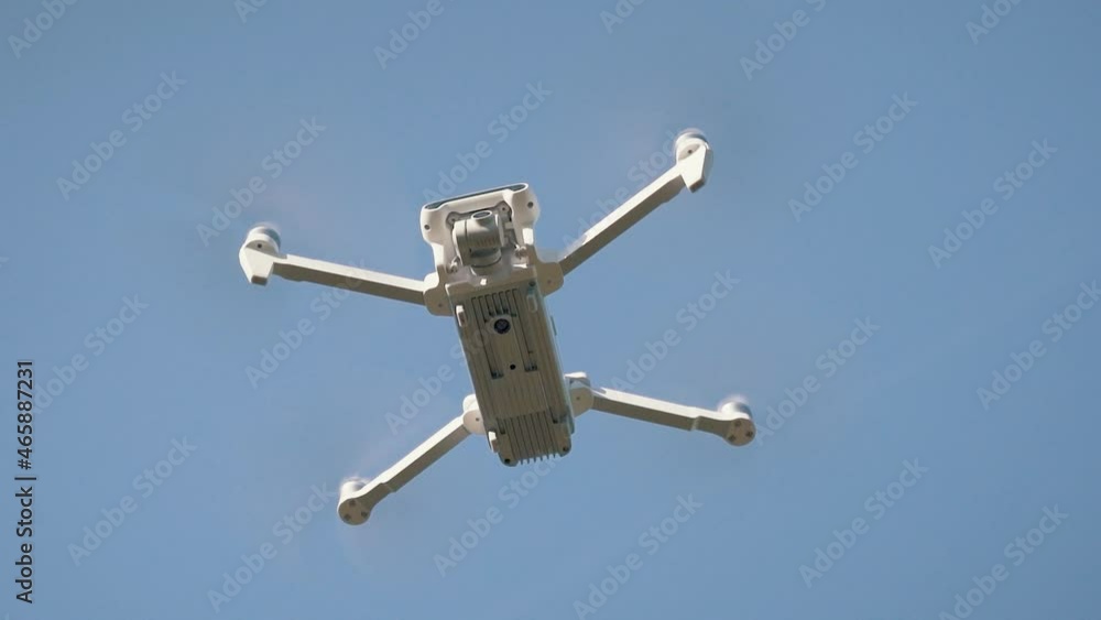 White Drone Flying on Nature Background. Drone Hanging in Air Flying Helicopter Dron Remote Control Air Drone. Slow Motion Shot. White Drone Flying on Nature Background. Drone Hanging in Air Flying Helicopter Dron Remote Control Air Drone. Slow Motion Shot.