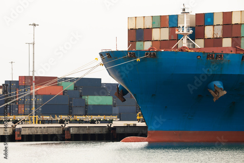 A cargo vessel full of containers sits docked at port. photo