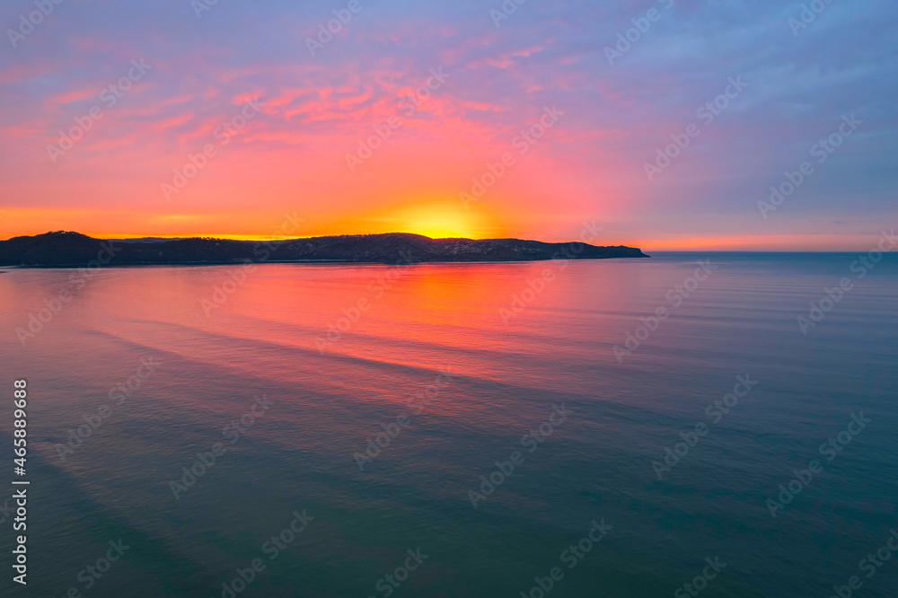 Obraz premium One hundred percent colourful cloud covered sunrise over the sea
