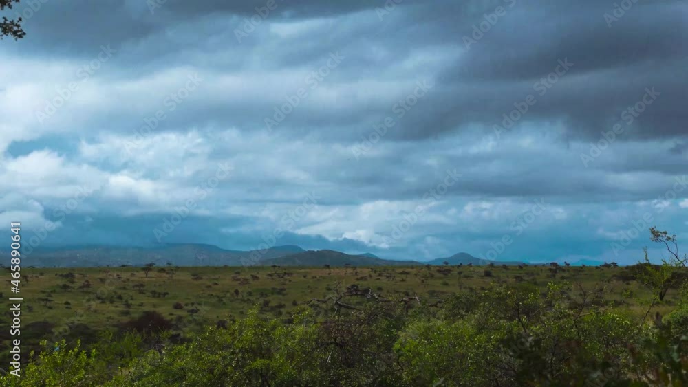 Time lapse shot of flying clouds over Safari National Park in Kenya with rural landscape and mountains in background,Africa Time lapse shot of flying clouds over Safari National Park in Kenya with rural landscape and mountains in background,Africa