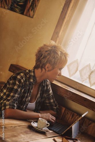 young woman in a country resteurant working at laptop photo