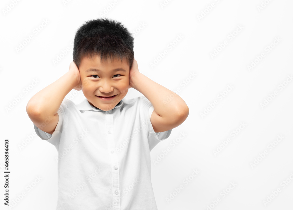 Kid with hands closing ears, wearing white shirt on white background Kid with hands closing ears, wearing white shirt on white background