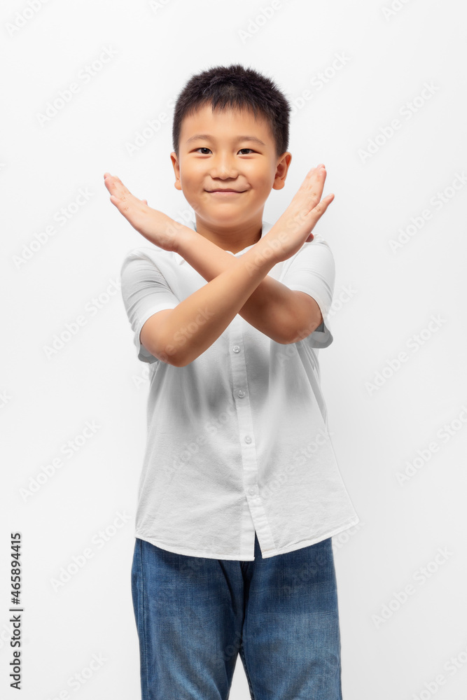 Kid crossed hands, posing stop sign with smile on white background Kid crossed hands, posing stop sign with smile on white background