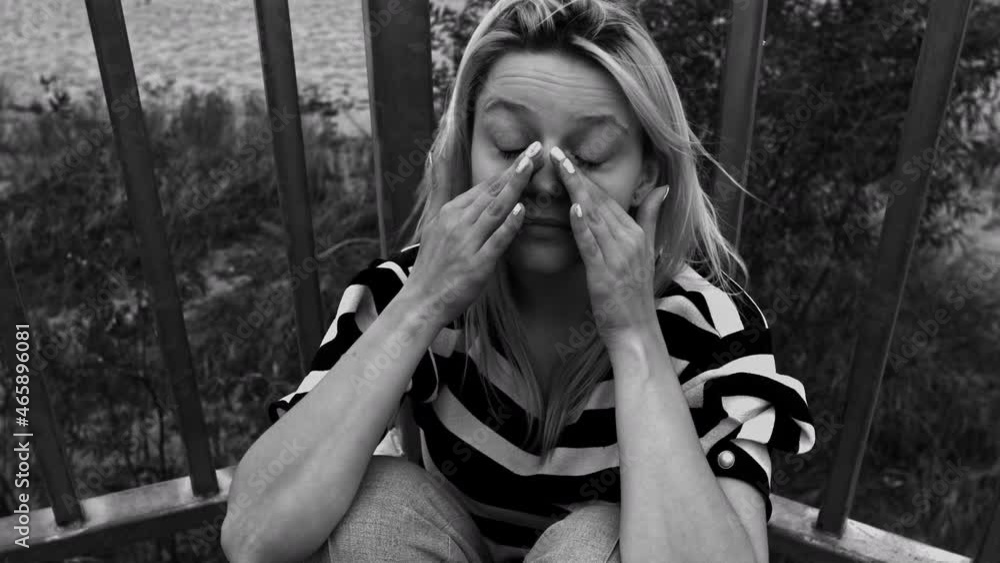An unhappy woman sitting alone in a windy weather with her hands