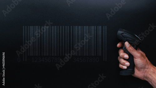 Barcode scanning. Reader laser scanner for warehouse. Retail label barcode scan on dark background. Warehouse inventory management. photo