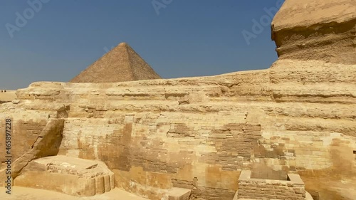 Scenic and cinematic 4K footage of the big Kefren King Pyramid and the Sphinx on a sunny day in Egypt while camel riding. Concepts of monuments, tourism industry and travel to Egypt. photo