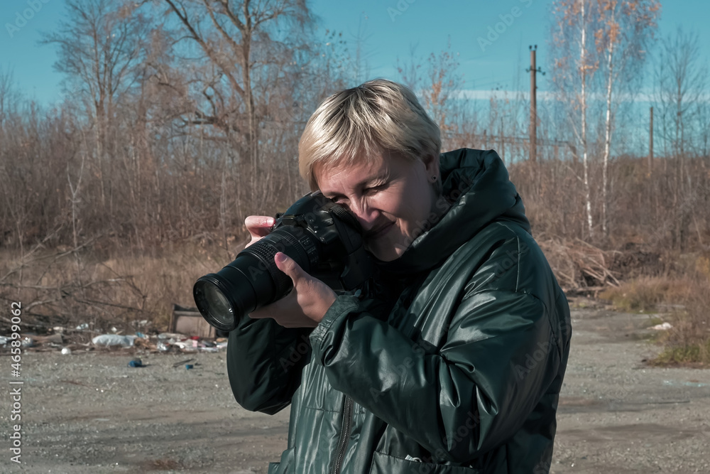 a female forensic photographer with a camera takes pictures of nature.