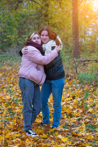 two red-haired smiling girls against the background of autumn nature, the concept of human emotions © Petr