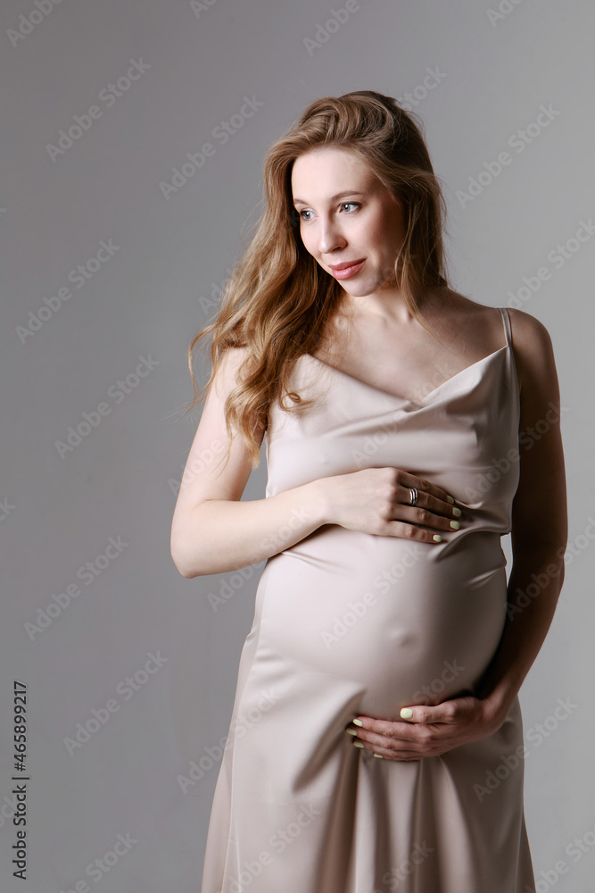 caucasian pregnant woman stroking her belly on white background. Copy space. The concept of healthy digestion, lifestyle, IVF caucasian pregnant woman stroking her belly on white background. Copy space. The concept of healthy digestion, lifestyle, IVF