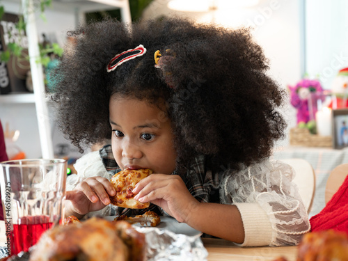 Happy girl children with afro hair eat pizza 